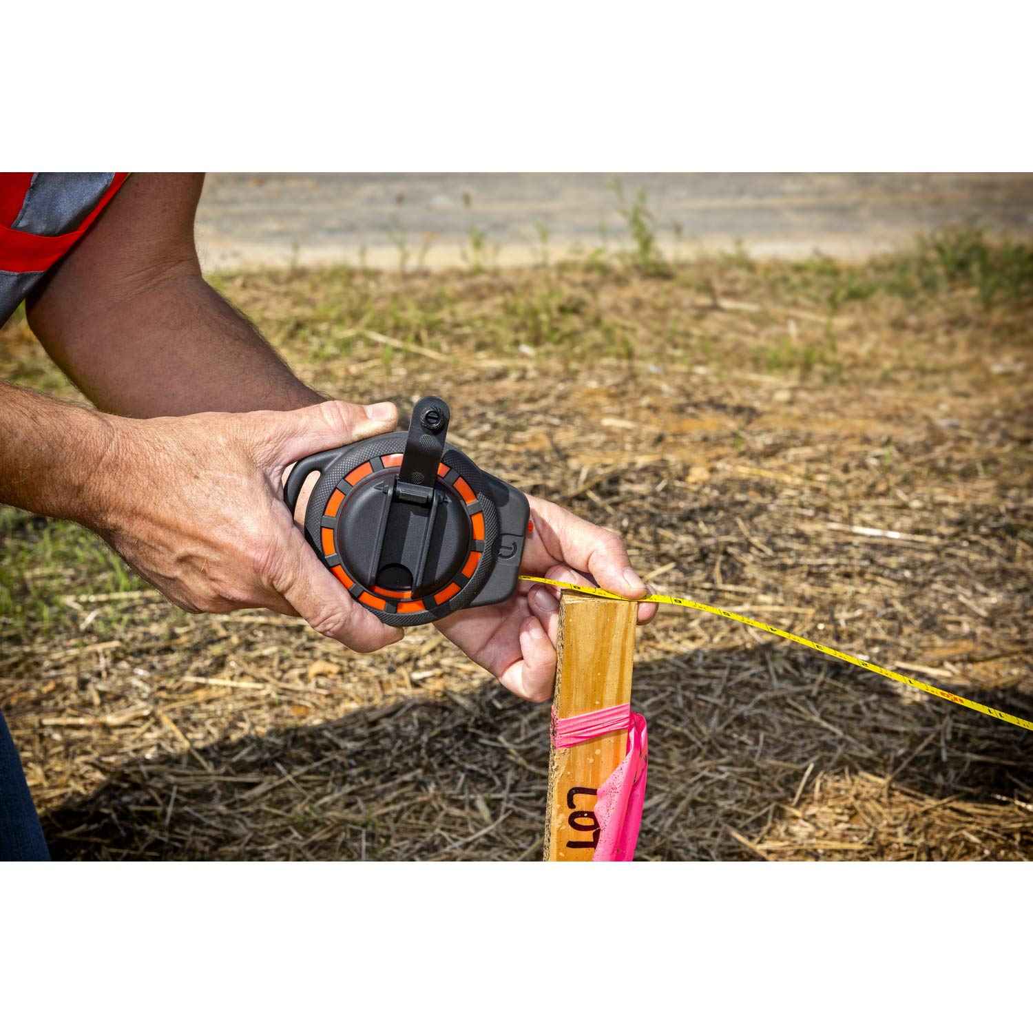 A detailed view of the Crescent Lufkin ST50-07 case being held by a professional, demonstrating the compact ergonomic design and the seated rewind handle that protects the crank assembly during storage.