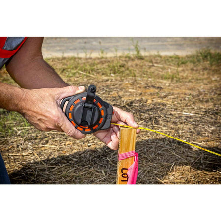 A detailed view of the Crescent Lufkin ST50-07 case being held by a professional, demonstrating the compact ergonomic design and the seated rewind handle that protects the crank assembly during storage.