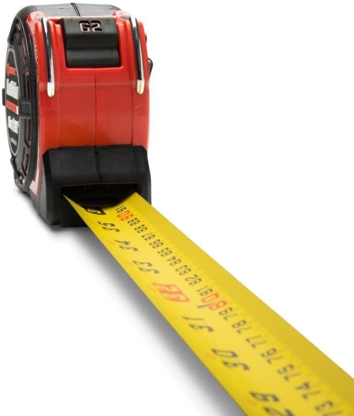 Perspective view of the Shockforce G2 tape measure with the dual-sided yellow blade extended, highlighting the high-contrast metric and SAE graduations and the industrial-grade auto-lock mechanism at the blade entry.
