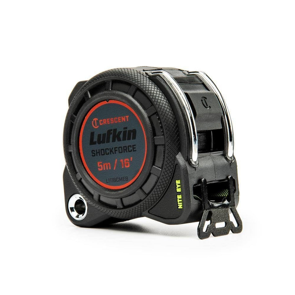 Angled view of the rugged black tape measure case showing the steel tether point and textured rubber grip.