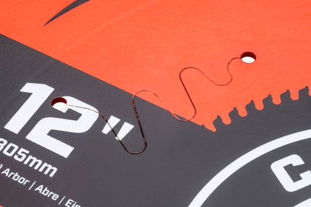 Laser-cut serpentine harmonic vibration slot on a Crescent 12-inch saw blade body designed to prevent blade warping.