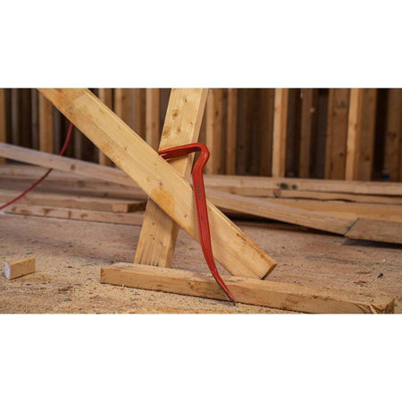 The Crescent 18-inch steel wrecking pry bar securely wedged into a wooden frame assembly, demonstrating the leverage provided by its curved gooseneck design.