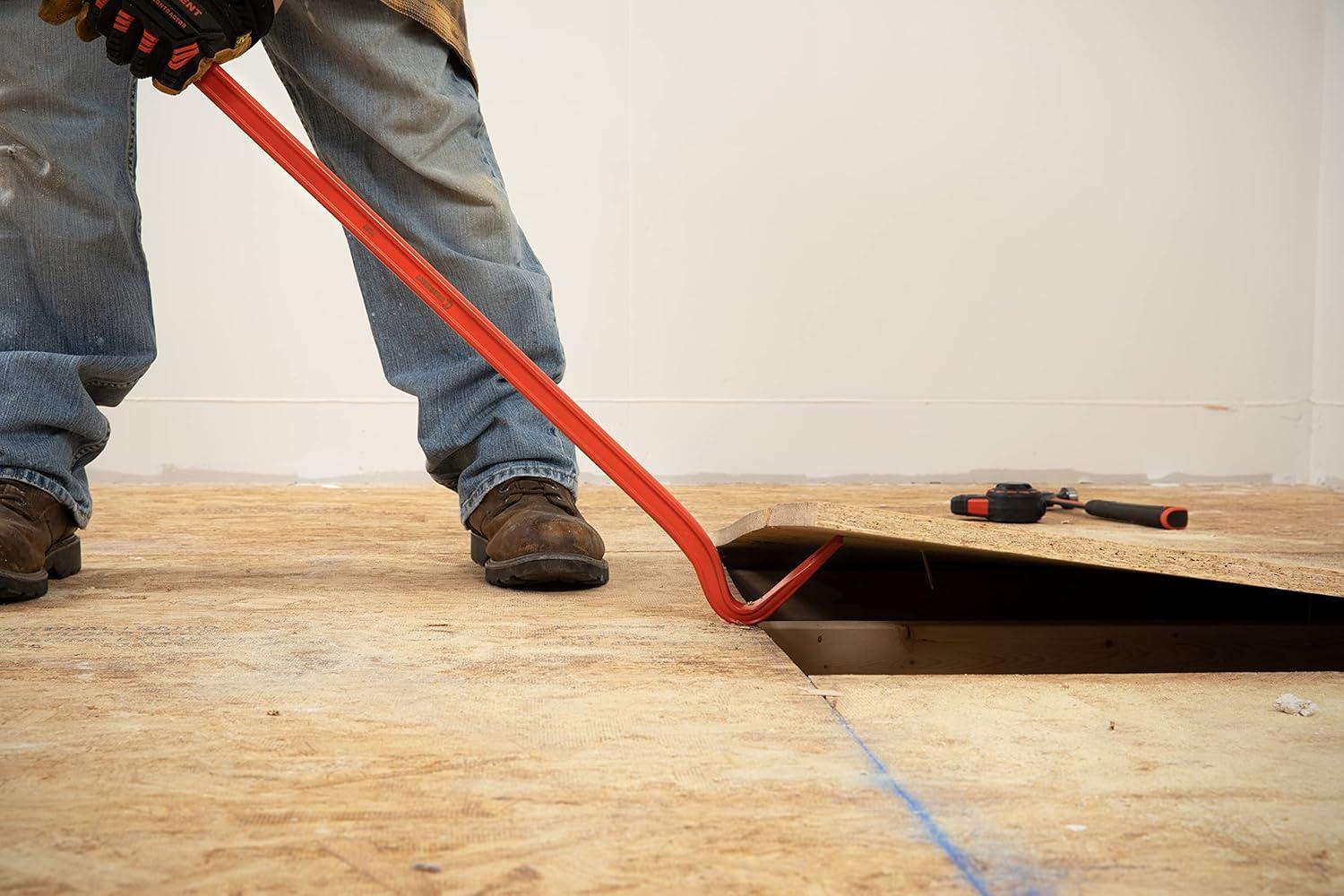 Close-up action view of the gooseneck end of the Crescent PB36 pry bar being used to lift a wooden floor board, highlighting the tool's ability to bite into tight gaps.