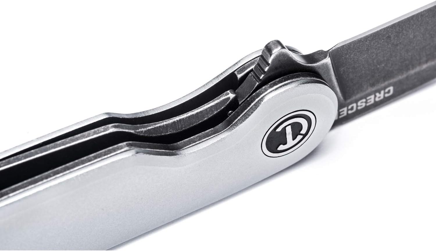 Extreme macro close-up detail focusing on the internal mechanical assembly of the opened pocket knife, displaying the heavy-duty manual ball-bearing track pivot ring and the robust steel liner lock tab firmly engaging the heel of the blade for enhanced safety.