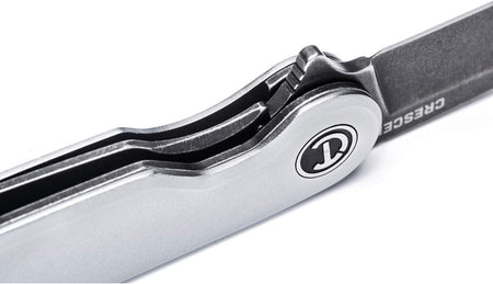 Extreme macro close-up detail focusing on the internal mechanical assembly of the opened pocket knife, displaying the heavy-duty manual ball-bearing track pivot ring and the robust steel liner lock tab firmly engaging the heel of the blade for enhanced safety.