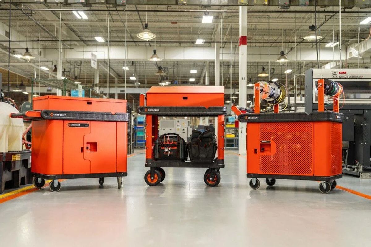 A lifestyle shot featuring three distinct configurations of the Crescent RAILWORKS cart system in a factory setting. The image shows a base cart with tool bags, a secure lockable workstation, and an electrical spool station, highlighting the versatility of this modular material handling solution.