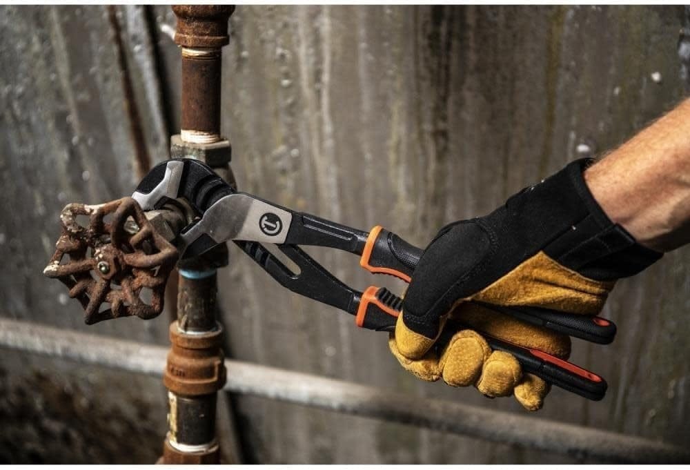 Action shot of a professional tradesman using the Crescent 12-inch Z2 pliers with a high-leverage grip to turn a rusted metal valve on an industrial pipe.