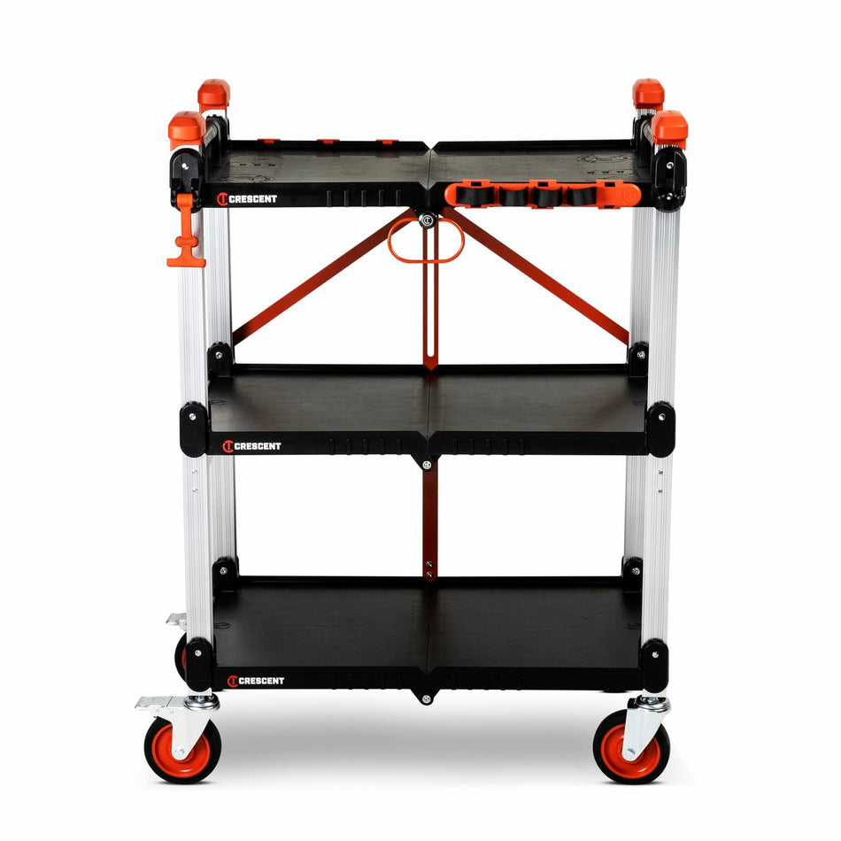 Three-tier Crescent jobsite cart with black shelves, aluminum posts, and red accents. The top shelf includes molded compartments for organizing tools. The cart has four caster wheels, two with brakes, and a side handle for mobility. “Crescent” branding is visible on each shelf.