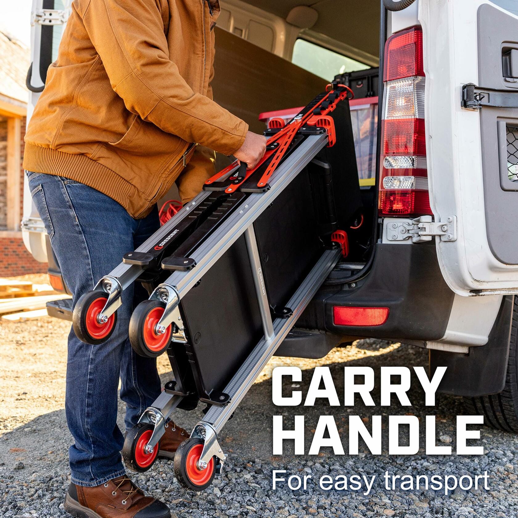 Person loading a foldable Crescent jobsite cart with red caster wheels into the back of a white van. The cart has a black frame and red handles. The person wears a brown jacket and jeans. Text overlay reads “CARRY HANDLE – For easy transport.”