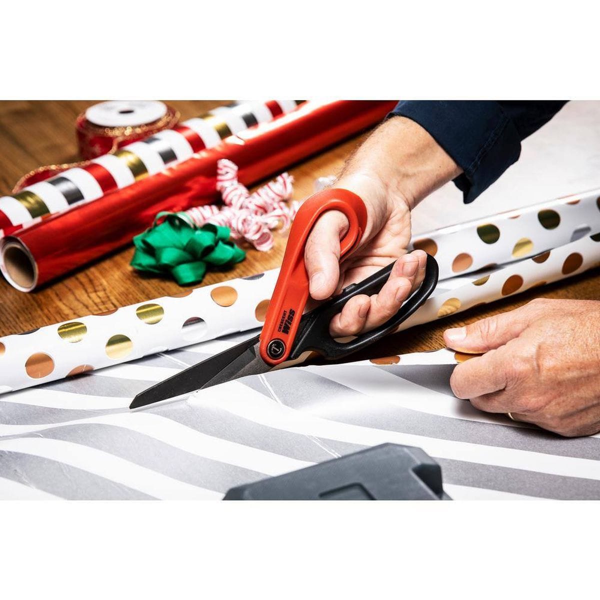 Industrial shears being used to cut through heavy laminated paper and metallic packaging materials, highlighting the smooth operation and precision of the titanium-coated blades.