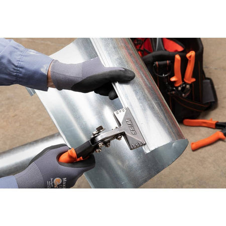 An action photograph of a professional using the Crescent Wiss WS4N offset hand seamer to bend a clean 90-degree edge on a piece of round galvanized sheet metal ductwork.