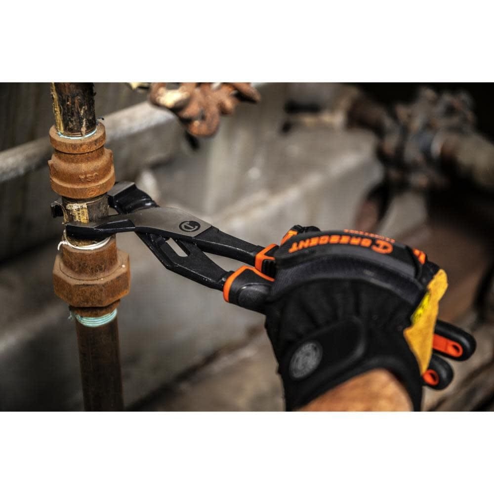 Close-up action shot of a gloved hand using the Crescent Z2 pliers to tighten a rusted metal pipe fitting in an industrial setting.