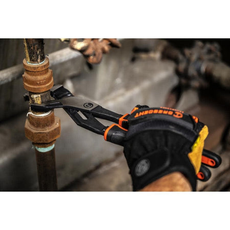 Close-up action shot of a gloved hand using the Crescent Z2 pliers to tighten a rusted metal pipe fitting in an industrial setting.