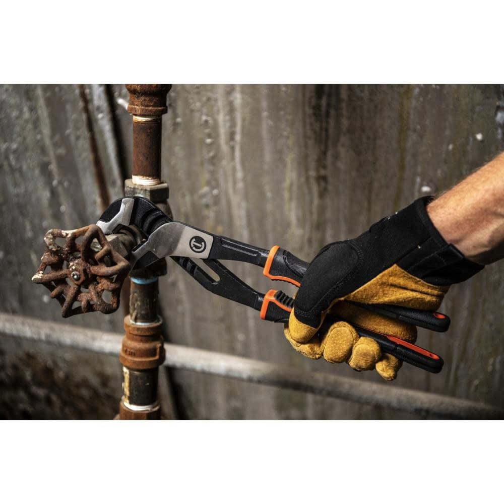 Action shot of a gloved hand using the Crescent Z2 pliers to grip and turn a rusted circular valve handle on a vertical pipe.
