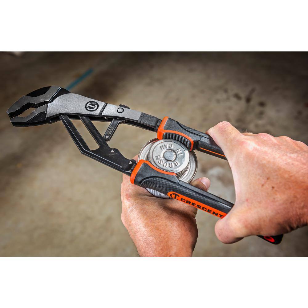 An overhead workspace application photograph showing a mechanic using the non-marring grip zone on the handles of the Crescent Z2 pliers to smoothly unthread the metal lid of a utility brush can.