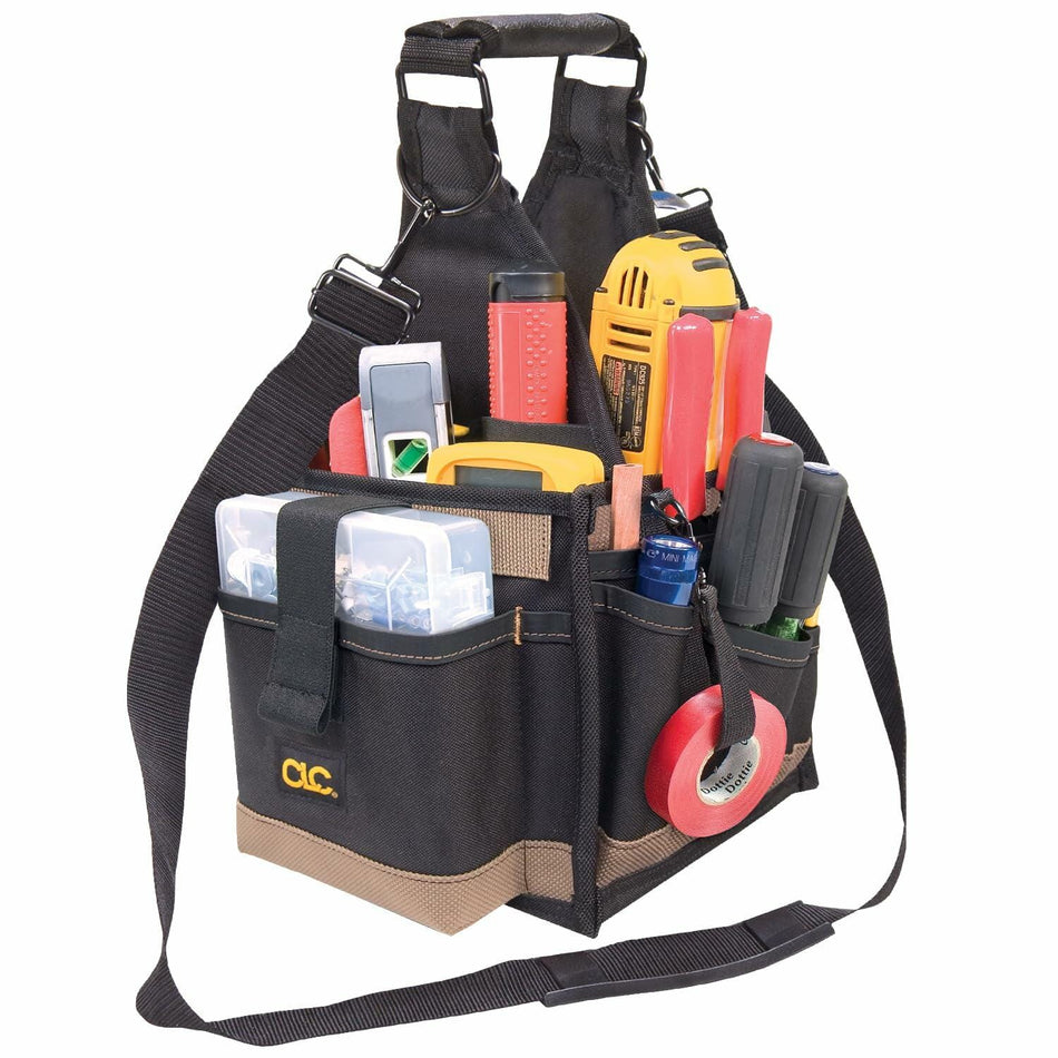 The Custom Leathercraft 25-pocket tool carrier bag, fully loaded with various hand tools, a drill, a clear plastic parts tray, and a roll of red electrical tape.