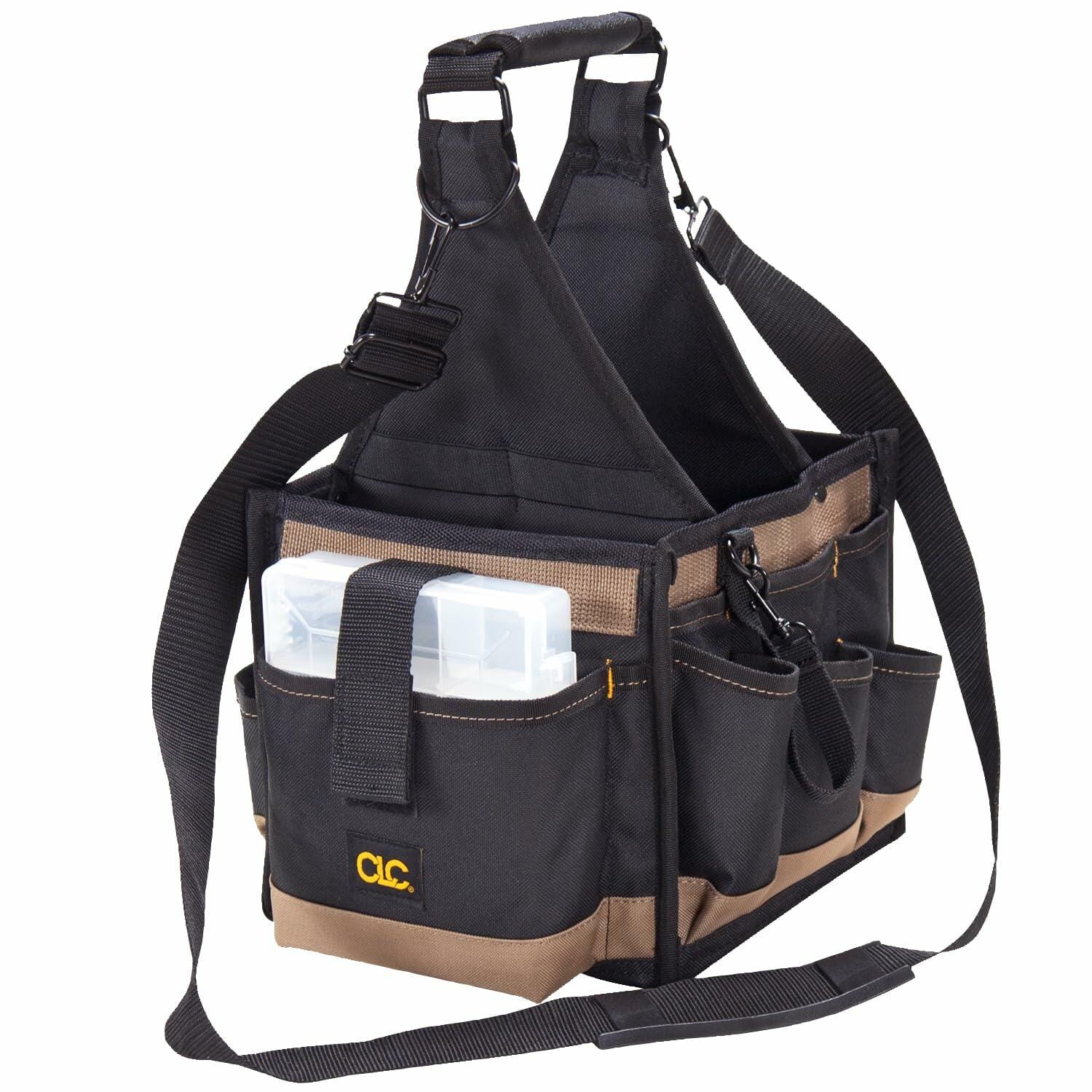 The Custom Leathercraft 25-pocket tool carrier bag viewed from an angle, empty but showing the black and tan fabric, the padded shoulder strap, and the included clear plastic multi-compartment parts tray secured in an exterior pocket.