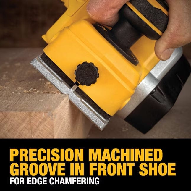 Person using DEWALT DCP580B planer to chamfer edge of wooden board; front shoe groove highlighted for edge chamfering.