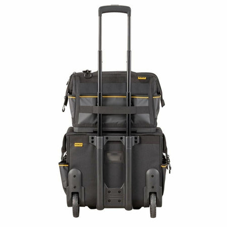 The back of the DEWALT Pro Tool Bag, showing its integrated strap being used to hang it securely on the telescoping handle of a rolling tool case.