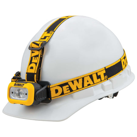 Right profile view of the DEWALT 200 lumen headlamp secured to a hard hat showing how the stability straps integrate with safety headwear for jobsite visibility.