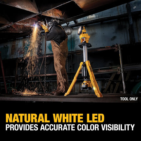 An action lifestyle shot of a welder working in a dark industrial setting illuminated by the DEWALT tripod light. A text overlay states Natural White LED Provides Accurate Color Visibility, showcasing the light’s ability to provide high-fidelity brightness in professional environments.