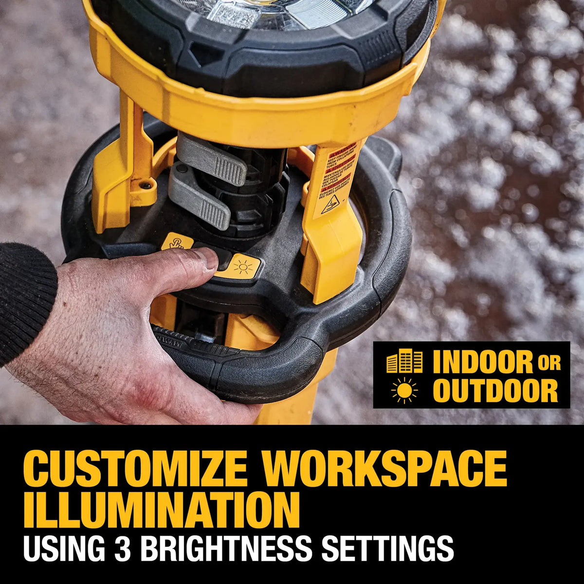 A close-up view of a technician's hand operating the controls on the DEWALT tripod light. The image highlights the three brightness settings button and the latch mechanism for the telescoping pole, with a text overlay confirming the light is suitable for indoor or outdoor use.