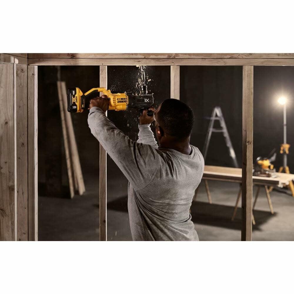 A tradesperson on a job site uses a DEWALT 20V MAX cordless reciprocating saw to cut through the top of a wooden wall stud.