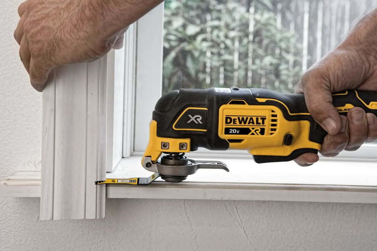 DEWALT 20V MAX XR Brushless Oscillating Multi‑Tool DCS356 trimming wooden molding near a window frame, demonstrating accurate detail cutting for carpentry and home improvement projects.