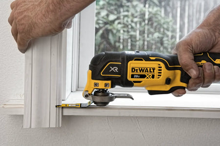 DEWALT 20V MAX XR Brushless Oscillating Multi‑Tool DCS356 trimming wooden molding near a window frame, demonstrating accurate detail cutting for carpentry and home improvement projects.