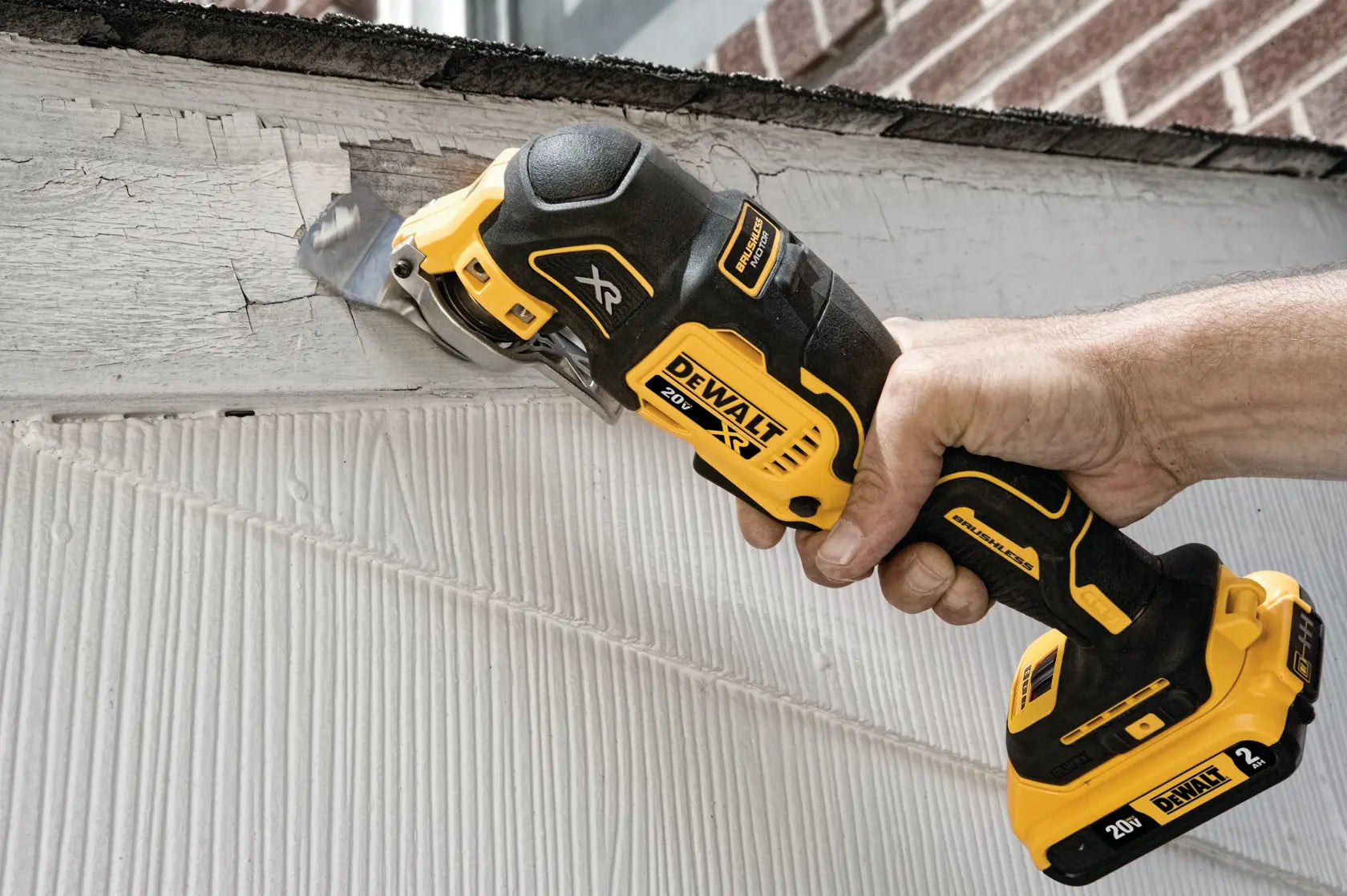 DEWALT 20V MAX XR Brushless Oscillating Multi‑Tool DCS356 sanding or scraping a damaged wooden surface, highlighting cordless versatility for renovation and surface preparation tasks.