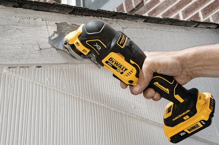 DEWALT 20V MAX XR Brushless Oscillating Multi‑Tool DCS356 sanding or scraping a damaged wooden surface, highlighting cordless versatility for renovation and surface preparation tasks.