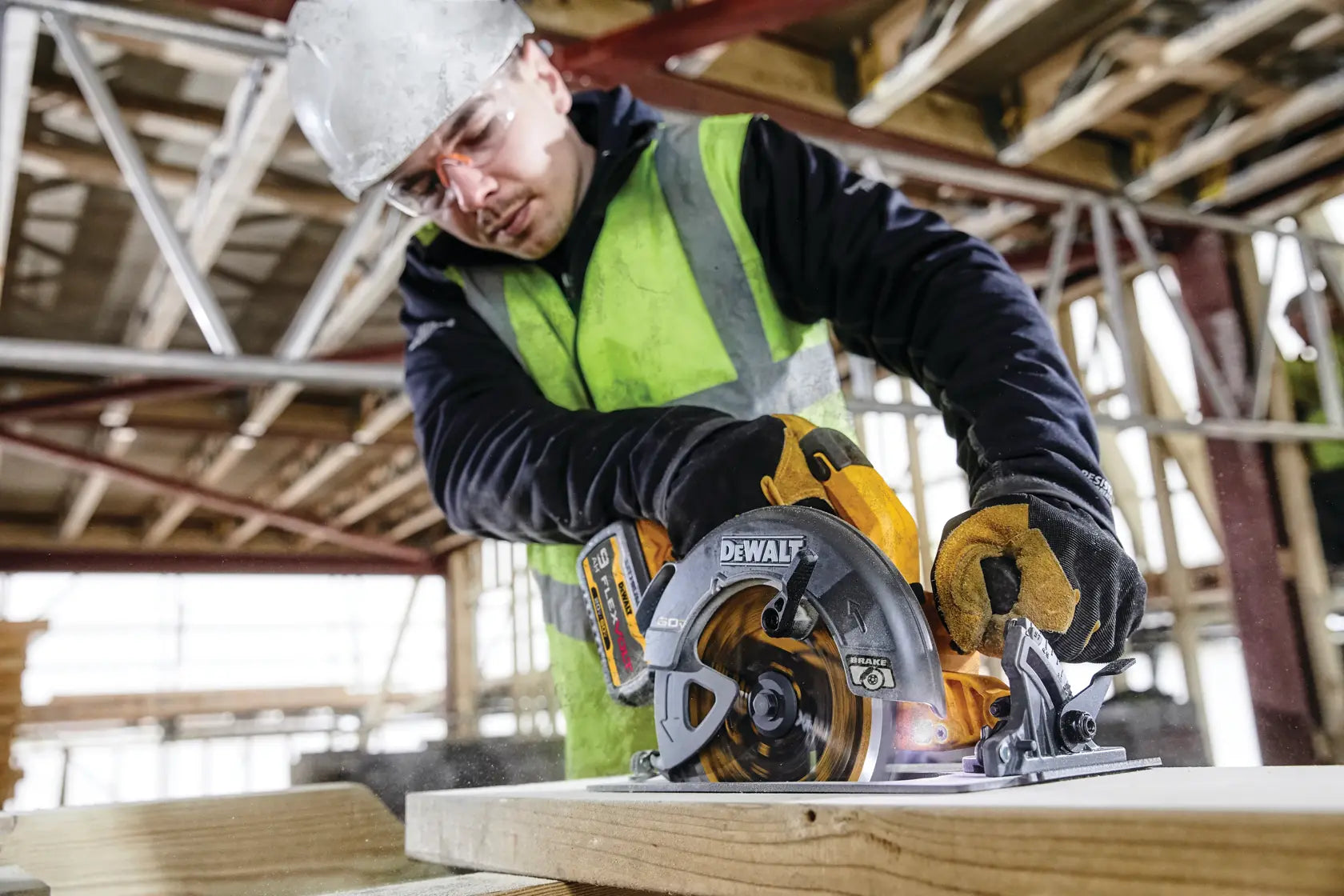 A wide action lifestyle shot of a technician wearing a hard hat and safety glasses while using the DEWALT 60V circular saw. The professional is making a vertical cut in a large timber beam, demonstrating the 7-1/4 inch blade’s capacity and the tool’s balanced weight for industrial construction tasks.