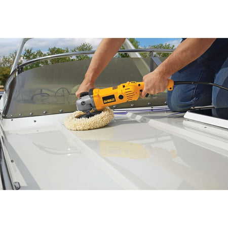 A close-up action shot of a professional using the DEWALT DWP849 7-inch to 9-inch variable speed polisher with a wool bonnet to restore and buff a white marine gelcoat surface on a boat.