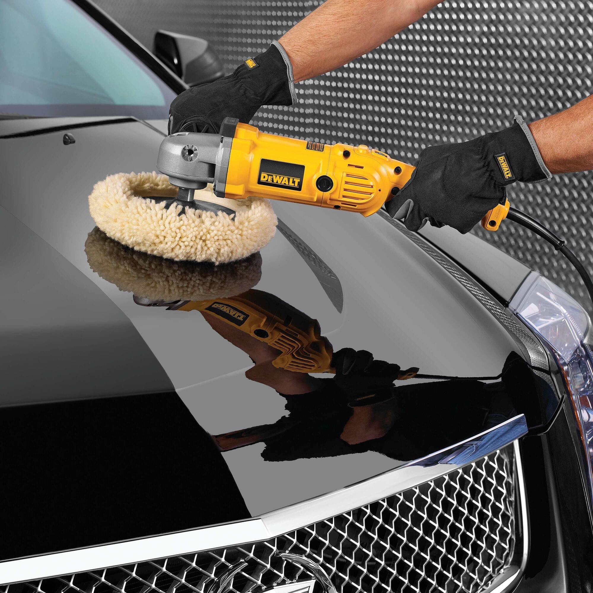 High-angle view of the DEWALT DWP849 rotary polisher in use on a black car hood, illustrating how the soft start and electronic speed control maintain a consistent, swirl-free professional finish.