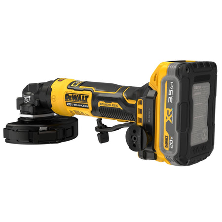 Oblique right side horizontal profile studio view of the DEWALT cordless compact angle grinder highlighting the technical warning label specifications screen, lower battery latch point, and clear brushless motor branding labels on the back side of the chassis case