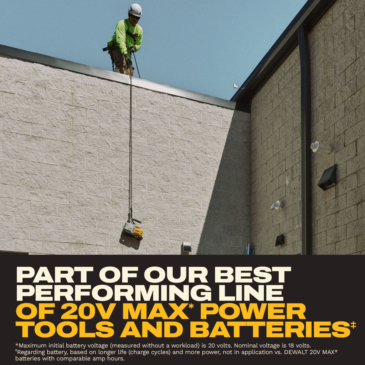 HVAC safety contractor looking down from a concrete block commercial roof edge while lowering or raising the DEWALT 20V MAX XR cordless vacuum pump via a heavy-duty work rope attached to the handle.