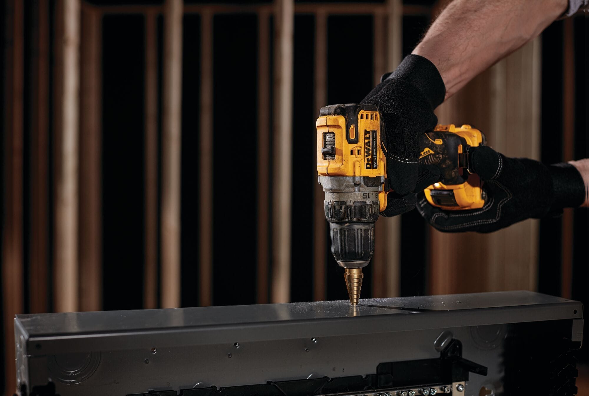Person using a DeWalt drill on a wooden surface with a blurred background
