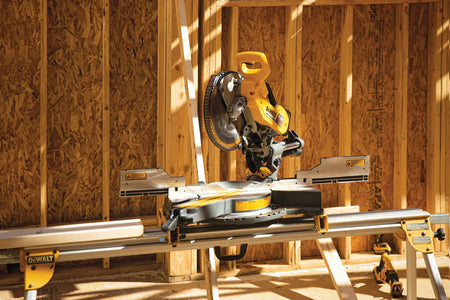 A wide lifestyle shot of a construction framing site featuring a DEWALT miter saw on a stand. The image demonstrates the intended environment for the Tool Connect system, where tags can be used to track valuable power tools and equipment across a large, busy residential jobsite.