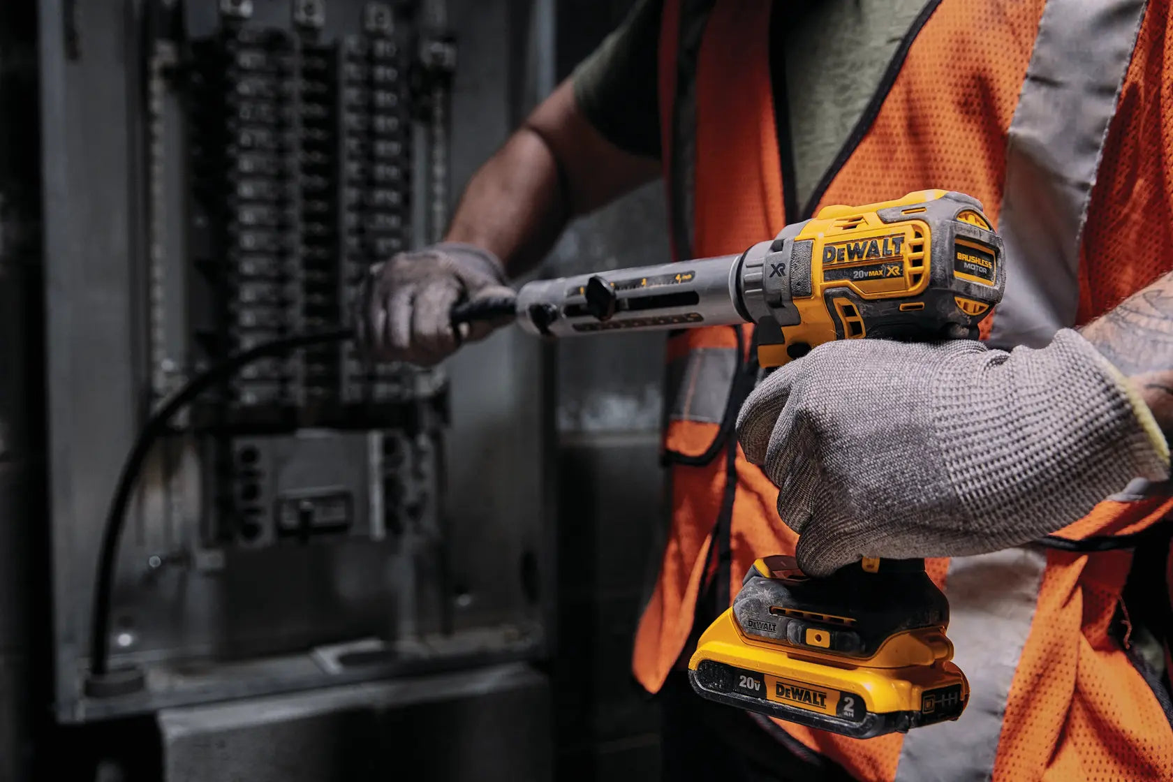 Action shot of a worker using the DEWALT DCE151B cordless cable stripper to precisely remove insulation from a copper wire for high-efficiency electrical panel assembly.