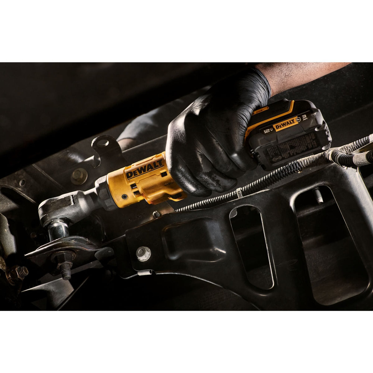 Alternative view of a technician using the 12V MAX brushless cordless ratchet to secure a fastener on a vehicle chassis, highlighting the compact power of the XTREME sub-compact series.