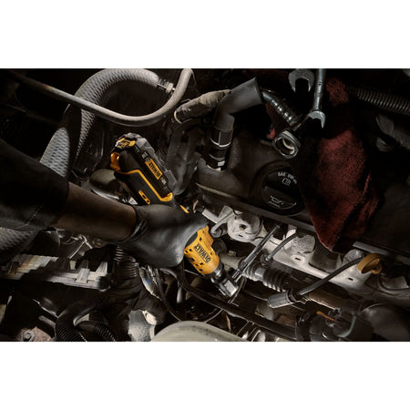 Top-down view of an automotive technician utilizing the DEWALT 12V MAX brushless 3/8-inch ratchet to navigate tight clearances within a vehicle's engine compartment during a repair.