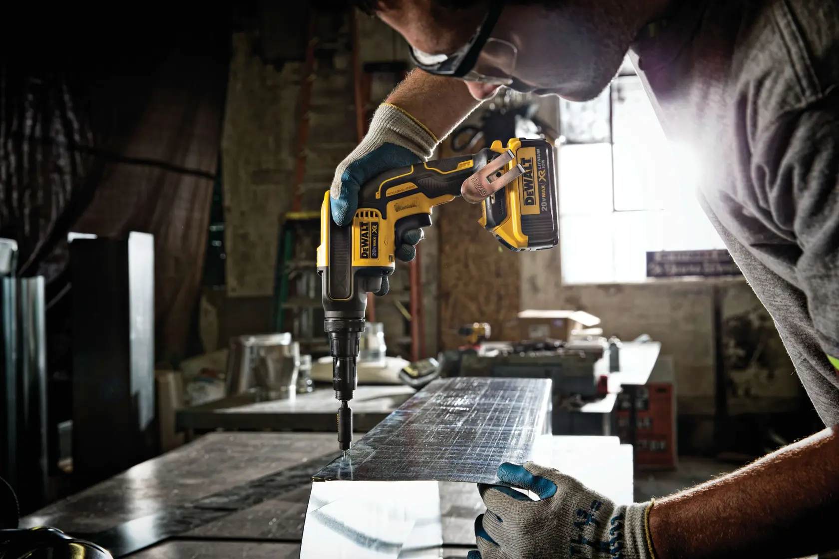The DEWALT 20V MAX XR cordless screwgun being operated in a professional workshop environment, highlighting the precision and control offered by the adjustable torque Versa-Clutch during heavy-duty fastening.