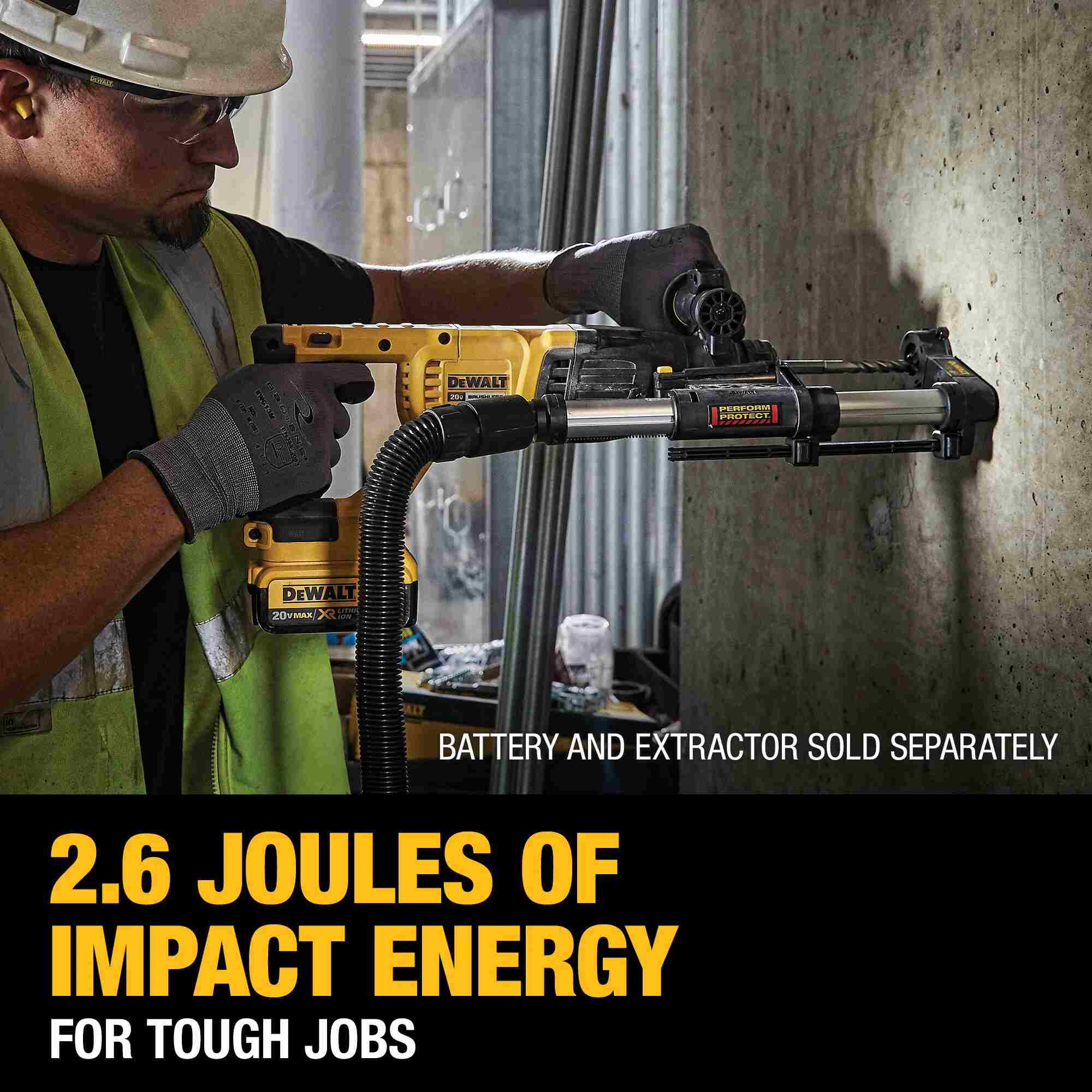 Action shot of a professional contractor using the DEWALT 20V MAX rotary hammer with a dust extraction attachment to drill high-accuracy holes into a vertical concrete wall.
