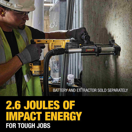 Action shot of a professional contractor using the DEWALT 20V MAX rotary hammer with a dust extraction attachment to drill high-accuracy holes into a vertical concrete wall.