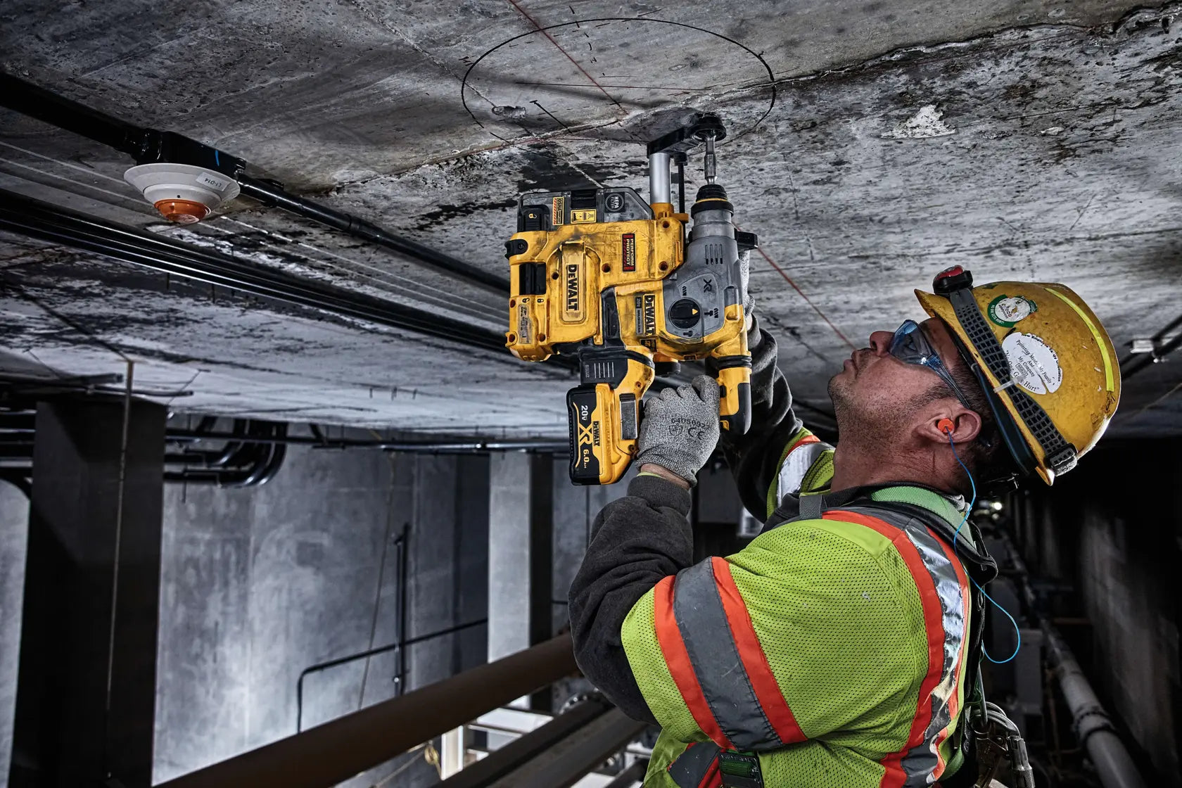 A lifestyle shot of a worker using the DEWALT 20V MAX XR SDS Plus rotary hammer to drill overhead into a concrete ceiling. The image highlights the tool's L-shape balance and the integrated dust extraction system, providing a clear view of precision rod hanging applications.