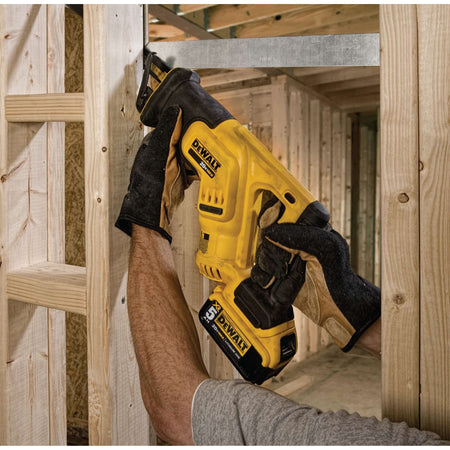 Person using a yellow Dewalt power drill in a construction setting.