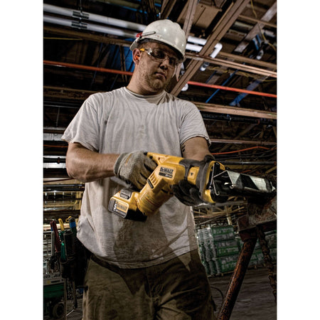 Man holding a yellow power tool in a warehouse setting