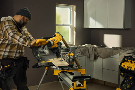 Action shot of the DEWALT 20V MAX XR 12-inch miter saw equipped with a vacuum hose, demonstrating the integrated Wireless Tool Control that enables automatic extractor activation for a cleaner jobsite.