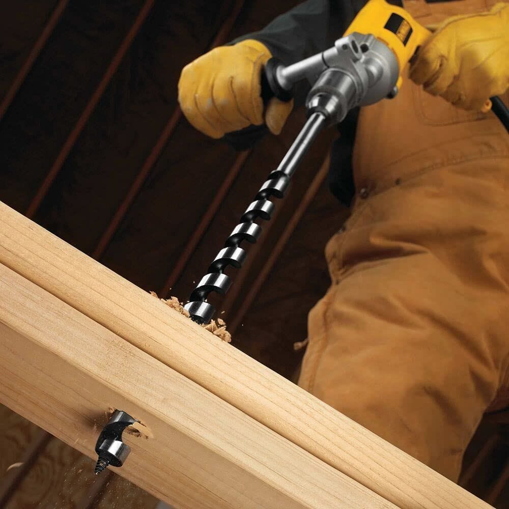 An action shot of a professional using a corded DEWALT drill to bore through thick structural timber with the DW1686 auger bit. Wood shavings are shown being aggressively extracted from the hole, demonstrating the bit's high-speed penetration and efficiency.