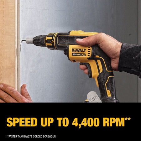 A close-up action shot of a professional using the DEWALT drywall screwgun to drive a fastener into a wall board, demonstrating the high-speed performance and ergonomic grip required for high-volume interior finishing.